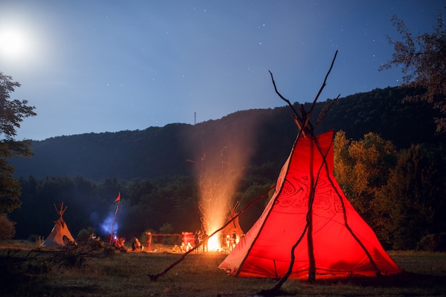 Gente acampando en un bosque por la noche.