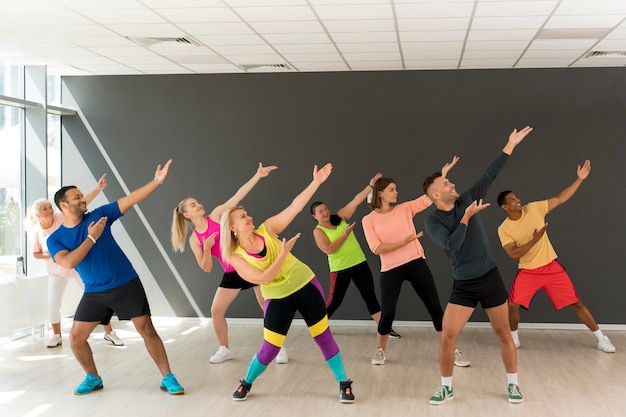 Foto gente activa divirtiéndose en clase de zumba.