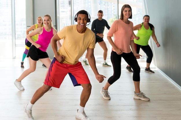 Foto gente activa divirtiéndose en clase de zumba.