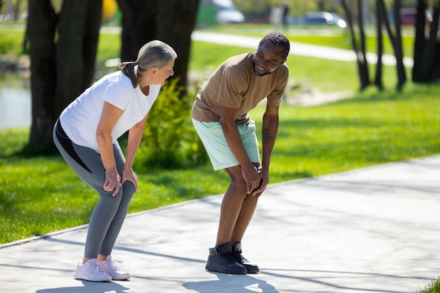 Foto gente activa una pareja haciendo ejercicio en el parque y haciendo sentadillas