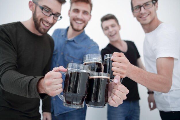 Gente alegre sosteniendo una gran jarra de cerveza llena de cerveza y mirando a la cámara aislada de fondo blanco