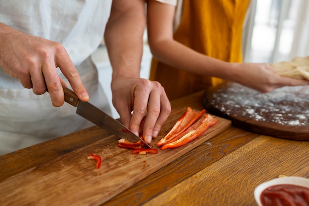 Foto gente de alto ángulo cocinando pizza