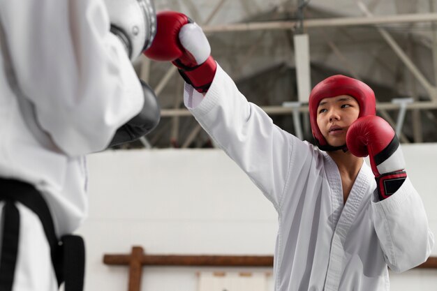 Gente de ángulo bajo practicando taekwondo.