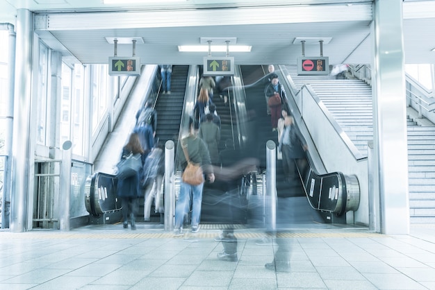 La gente se apresura en el movimiento de una escalera mecánica borrosa