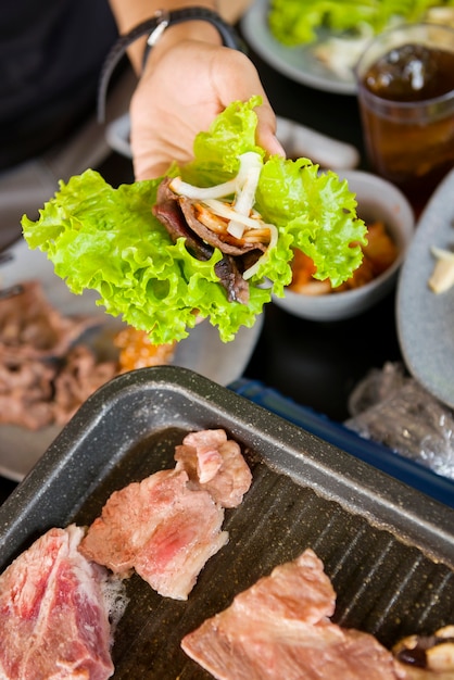 Gente asando barbacoa coreana en el restaurante