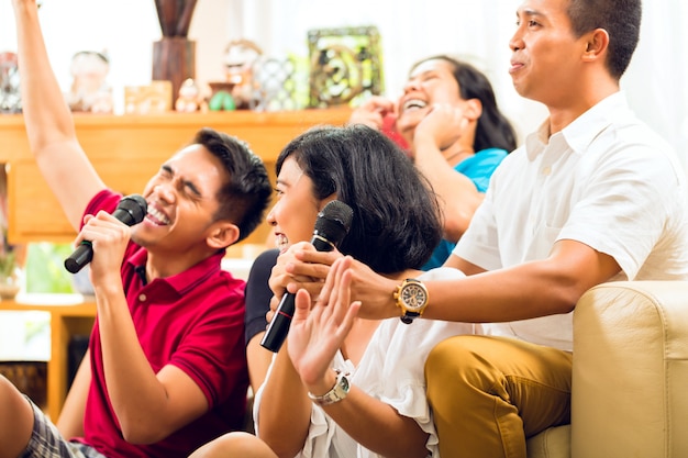 Gente asiática cantando en la fiesta de karaoke