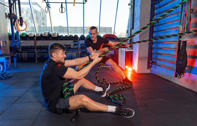 Gente atlética deportiva en el gimnasio moderno. Dos hombres activos haciendo ejercicio en el gimnasio.