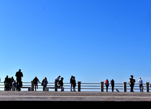 Foto la gente con barandillas contra el cielo azul claro