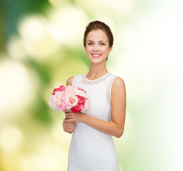 gente, boda, vacaciones y concepto de celebración - novia sonriente o dama de honor vestida de blanco con ramo de flores sobre fondo verde