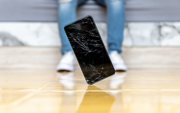 La gente cae teléfono inteligente en el piso pantalla rota