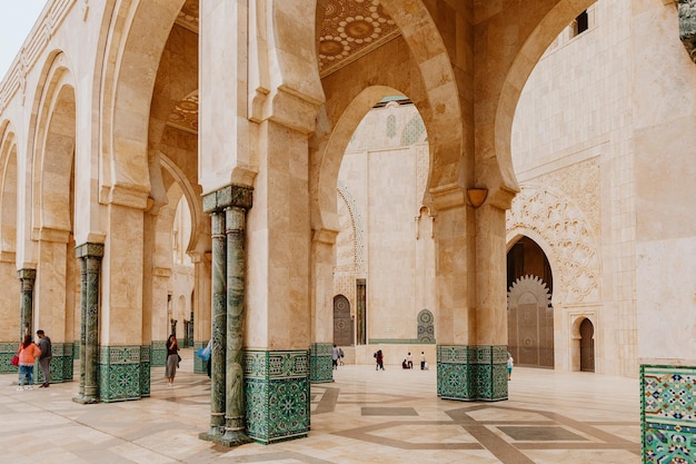 La gente camina cerca de las columnas de la mezquita de Hassan II en Casablanca, Marruecos