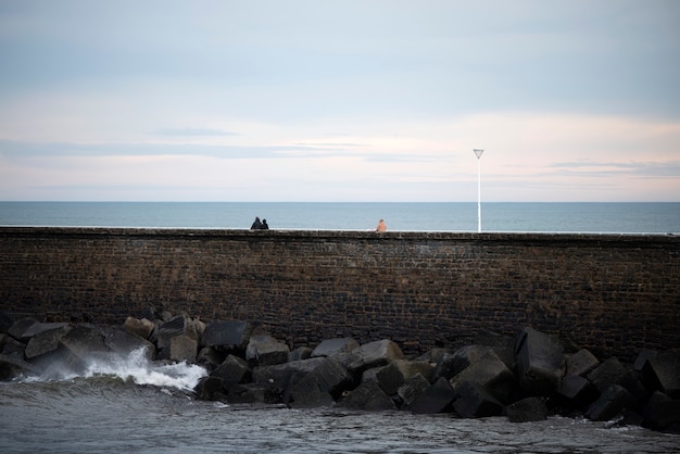 la gente camina sobre el rompeolas en san sebastian