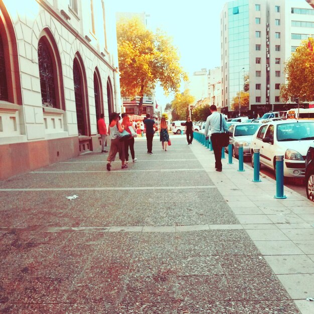 Foto gente caminando por la acera en la ciudad