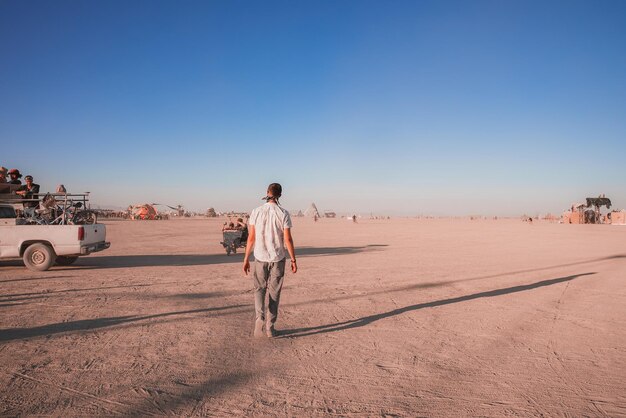 Gente caminando hacia el atardecer en un festival en el desierto