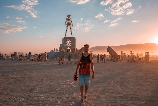 Gente caminando hacia el atardecer en un festival en el desierto