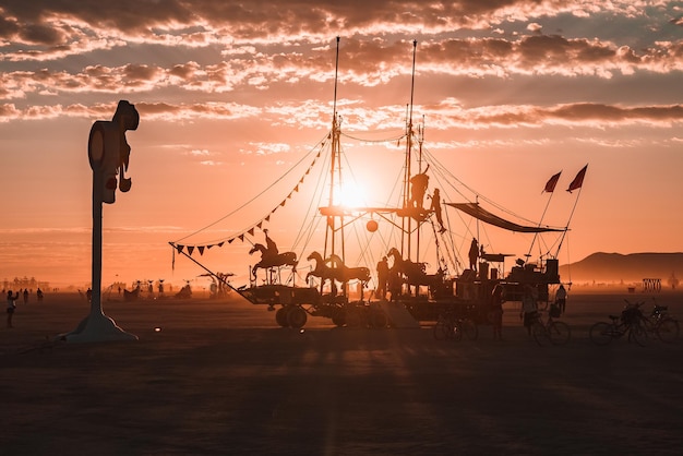 Gente caminando hacia el atardecer en un festival en el desierto