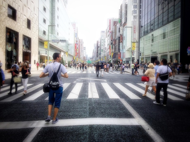 Foto gente caminando por la calle en medio de edificios en la ciudad