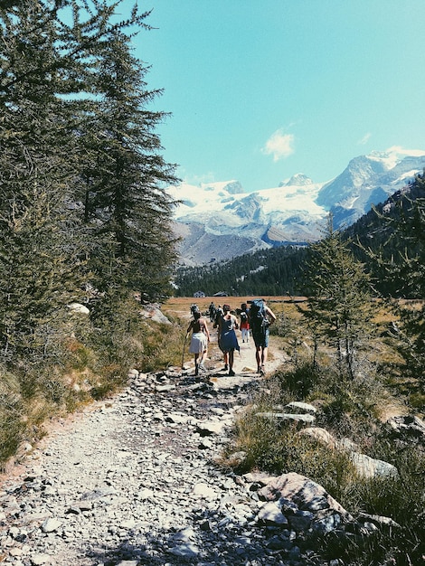 La gente caminando por el camino de la montaña contra el cielo