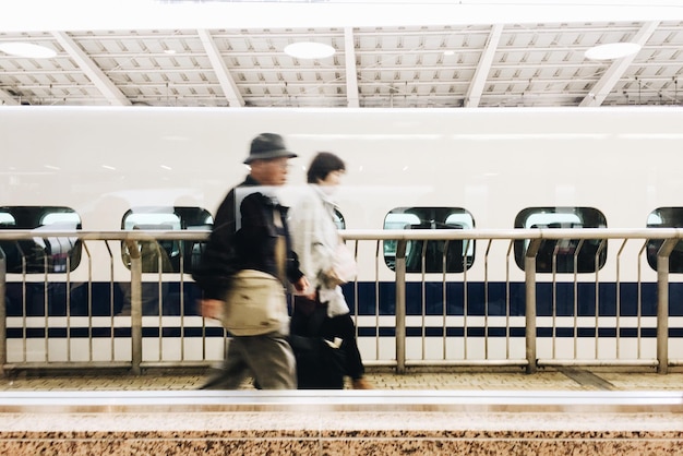 Gente caminando en la estación de tren contra el tren