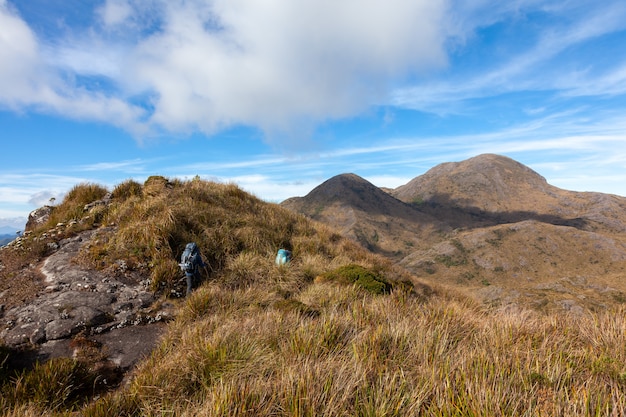 Gente caminando con grandes mochilas en el paisaje de montaña - trekking senderismo montañismo en la gama mantiqueira Brasil