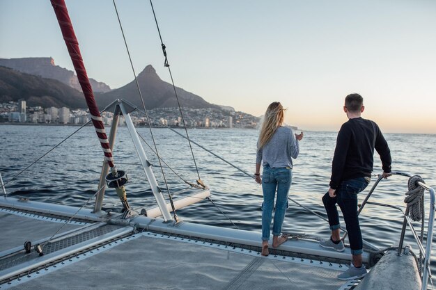 Foto gente caminando por el mar contra el cielo durante la puesta de sol