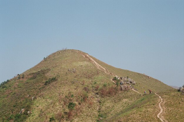 Foto la gente caminando por la montaña contra un cielo despejado