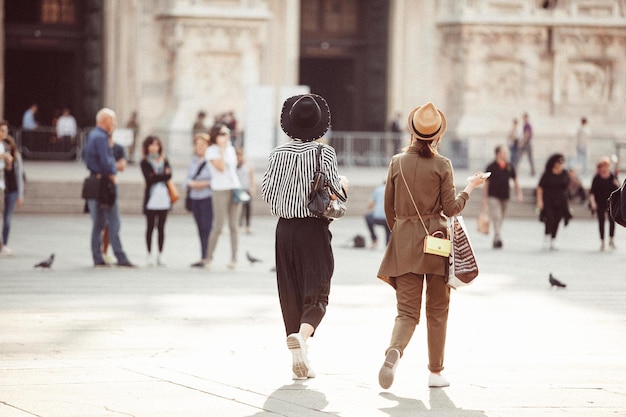 Foto gente caminando en la plaza de la ciudad junto al duomo de milán