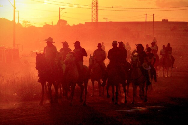 Foto la gente caminando por la tierra durante la puesta del sol