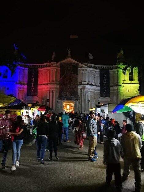 Foto la gente en la ciudad iluminada contra el cielo por la noche