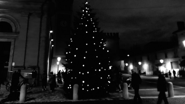 Foto la gente en la ciudad iluminada por la noche