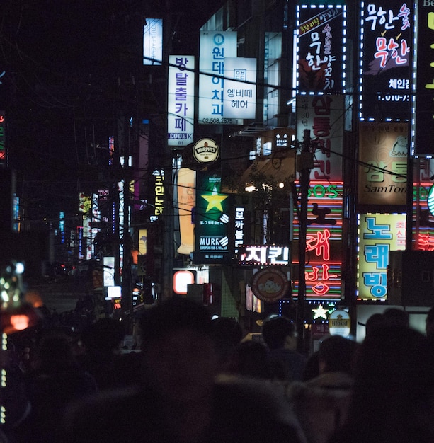 La gente en la ciudad iluminada por la noche