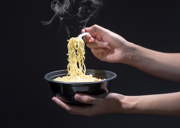 La gente come los fideos con un tenedor