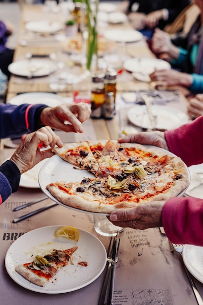 Gente comiendo pizza en un restaurante con un cartel que dice brunch.