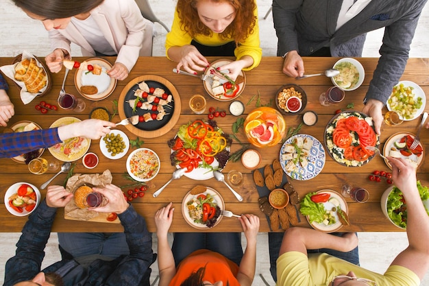 Gente comiendo, vista de mesa servida, cena. Fiesta casera