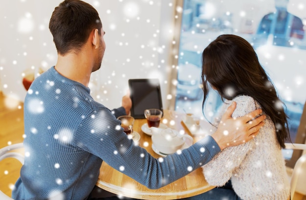 gente, comunicación y concepto de citas - cerca de una pareja feliz con una computadora de tablet pc en un café o restaurante