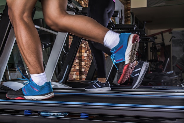 Gente corriendo en la caminadora en el gimnasio