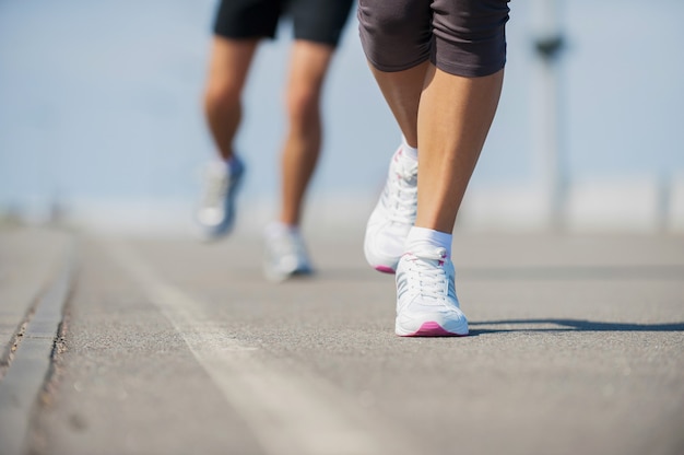 Gente corriendo. Imagen cercana de mujer y hombre corriendo a lo largo de la pista de atletismo