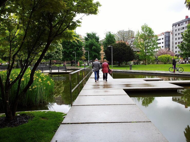 Foto gente cruzando un puente en un parque urbano