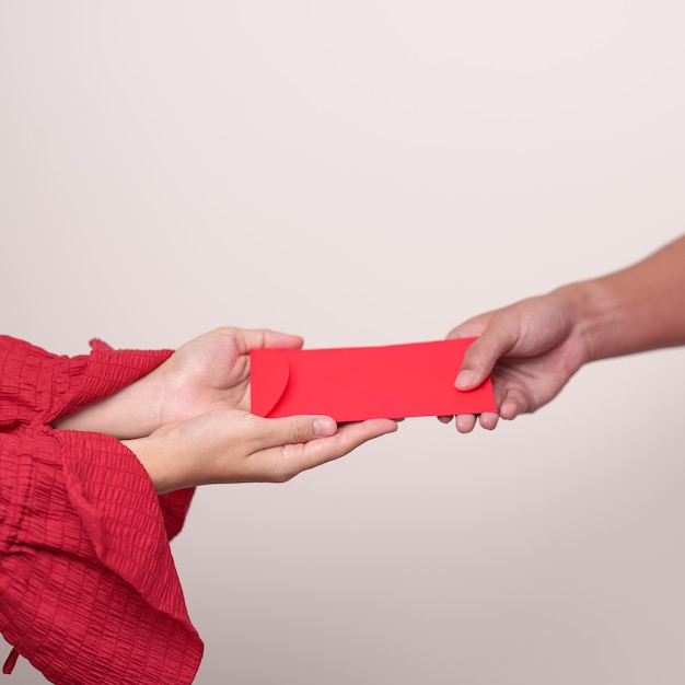 La gente da a mano un regalo de dinero de sobre rojo chino para felices vacaciones de Año Nuevo Lunar