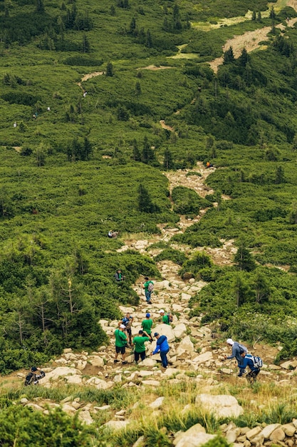 La gente desciende por una gran cordillera verde senderismo en la montaña