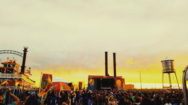 Foto la gente disfruta en el festival contra el cielo durante la puesta de sol