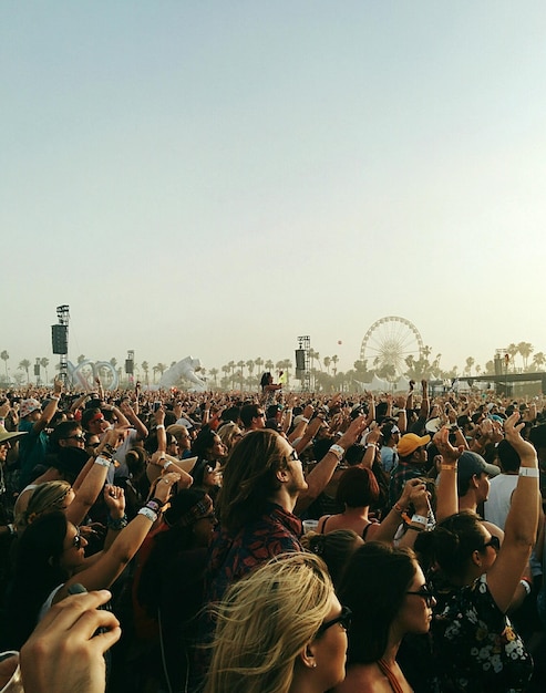 Foto gente disfrutando de un concierto contra un cielo despejado