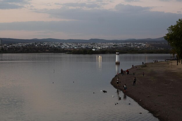 Gente disfrutando de unas vacaciones junto al lago en el parque solo unos minutos antes del atardecer