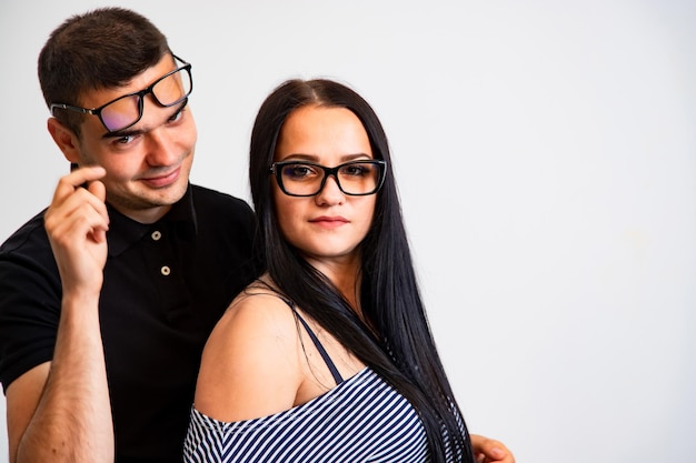 Gente elegante sobre fondo blanco Encantadora pareja joven con gafas