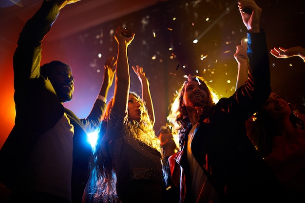 Gente emocionada bailando en concierto en discoteca