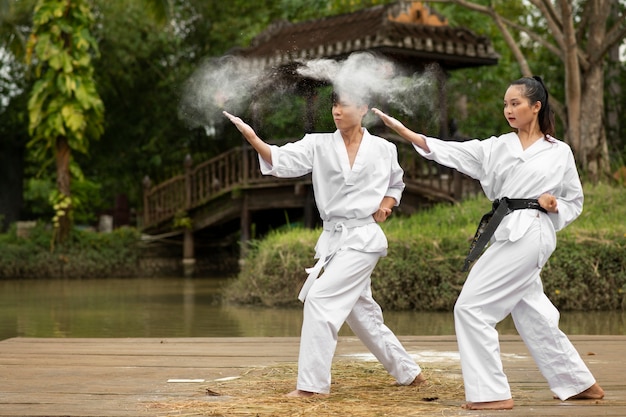 Foto gente entrenando juntos al aire libre para taekwondo