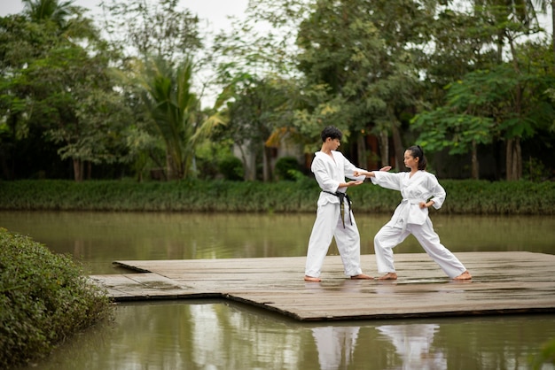 Foto gente entrenando juntos al aire libre para taekwondo