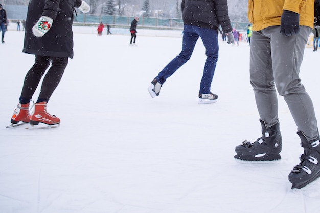 La gente esquía en la pista de hielo exterior en el día de invierno