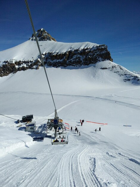 Gente esquiando en una montaña cubierta de nieve contra el cielo