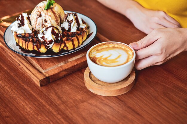 La gente está bebiendo café con leche en la mesa de madera